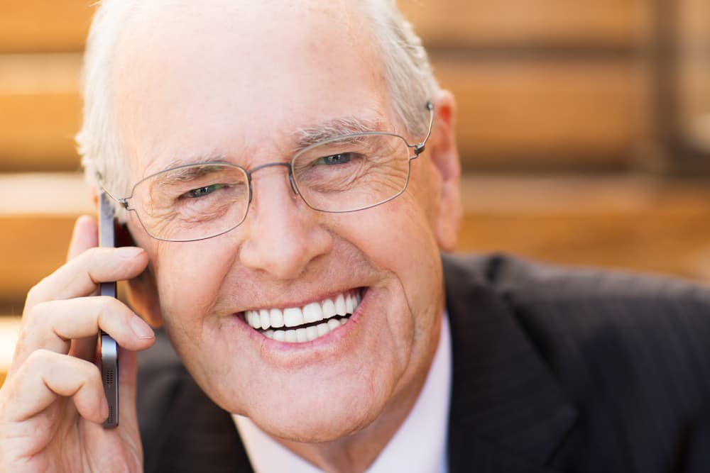 Ein Mann telefoniert lächelnd.