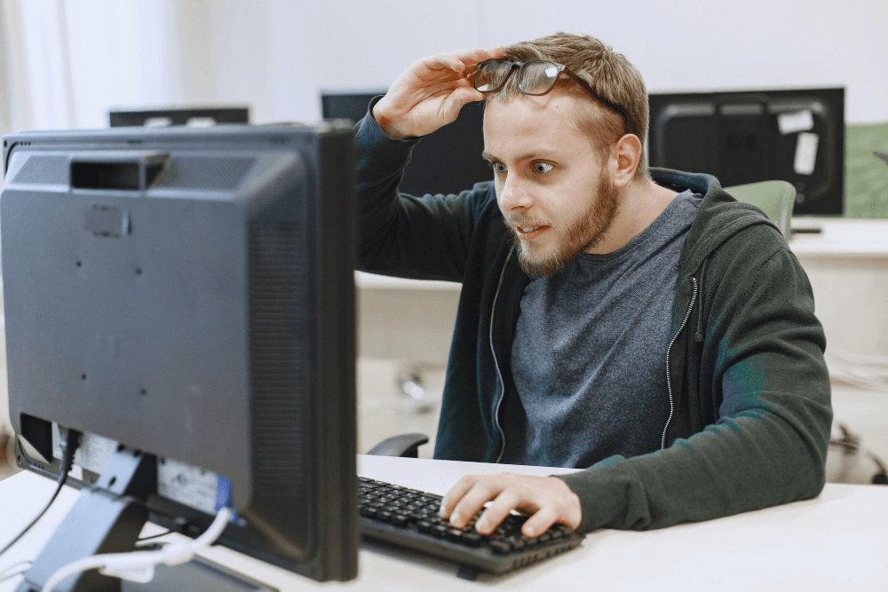 Ein Mann schaut erstaunt auf einen Monitor vor ihm.