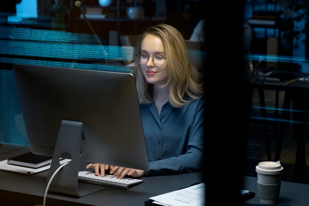 Eine Frau arbeitet alleine an einem Computer.